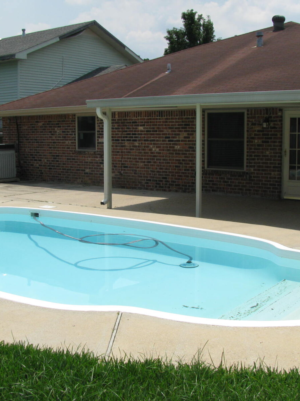 A crystal-clear backyard pool maintained by Your Pool Company